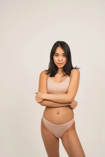 Photo of natural woman face, wears underwear. Isolated over white background. Natural beauty and health. Clean skin and cute smile