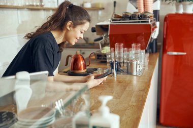Barista akıllı telefondan müşteriden sipariş alıyor. Kafe ve kafe kavramı küçük işletme
