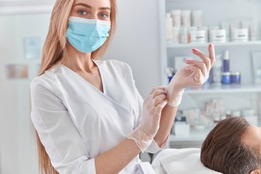 Sakallı çekici bir adam yüz masajından önce sırt üstü yatar. Yüz masajı güzellik tedavisi. Sağlık, güzellik ve rahatlama konsepti