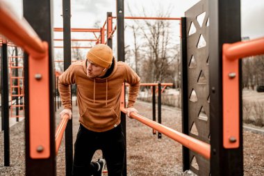 Spor kıyafetli genç adam dışarıda sabah antrenmanı yapıyor. Genç adam sokak sporları sahasına yanaşıyor. Formda ve sağlıklı konsept