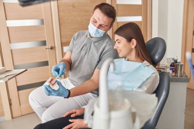 Diş hekimi muayenesi. Diş sağlığı kliniğine hasta ziyareti. Diş hekimi, ağız kontrolü çene ve dişlerini gösteriyor