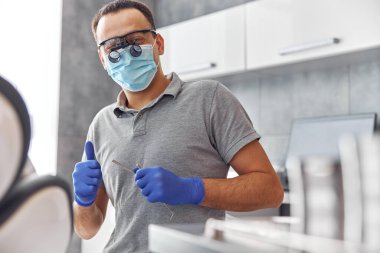 Modern diş cerrahisi, hasta üzerinde çalışan bir kadın doktorun yüzü. Diş hekimliği bürosundaki bir hastaya diş implantı ameliyatı