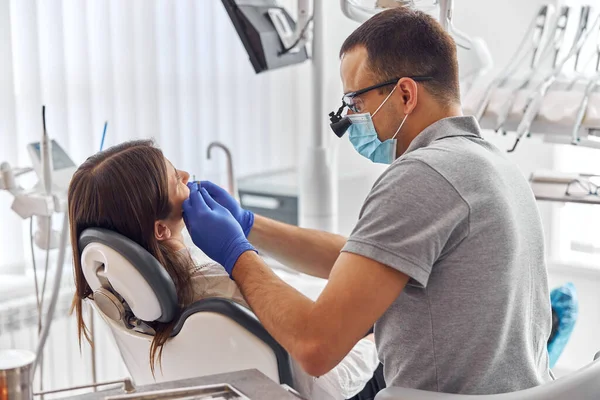 Dentista sério em máscara e ficar cliente e verificar a condição dos dentes. Conceito de saúde e medicina — Fotografia de Stock