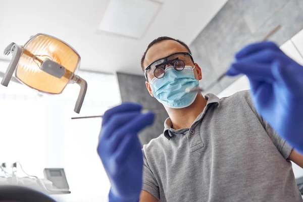 Cirurgia dentária moderna, rosto de uma médica a trabalhar num paciente. Operação de implantação dentária em um paciente em consultório odontológico — Fotografia de Stock