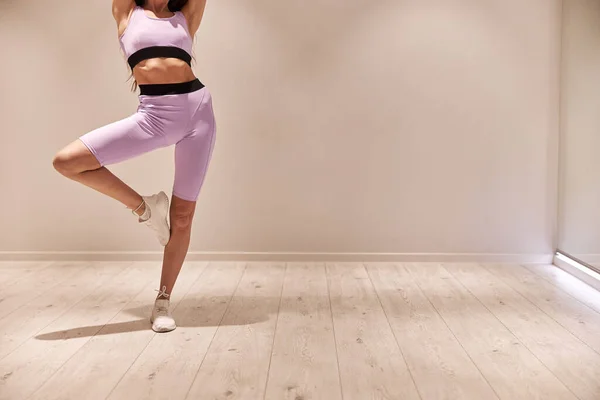 Atleta femenina estirando las piernas y haciendo ejercicio. Entrenamiento intensivo de entrenamiento físico en el gimnasio industrial loft — Foto de Stock