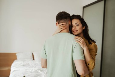 Mutlu genç çift sarılıyor ve duygularını gösteriyor. Kapatın. Genç aile yeni bir daireye taşınıyor.