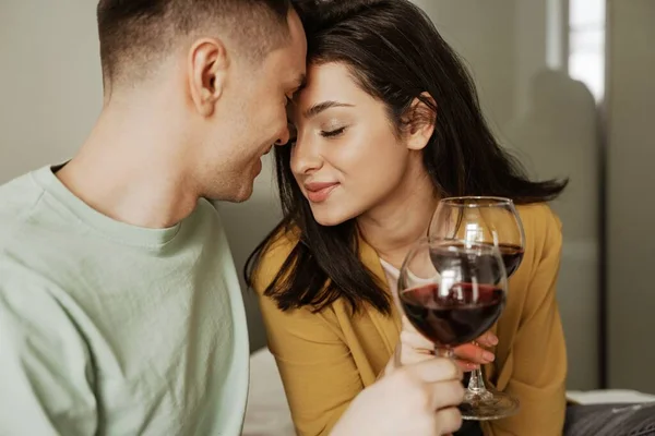 Прекрасна пара з келихами вина має романтичну вечерю вдома. Щаслива молода сім'я переїхала в нову квартиру — стокове фото