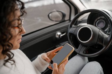 Avrupalı kız otomobilde cep telefonu kullanıyor