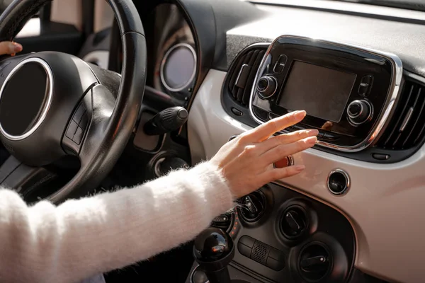 Femme main poussant écran moniteur dans la voiture — Photo