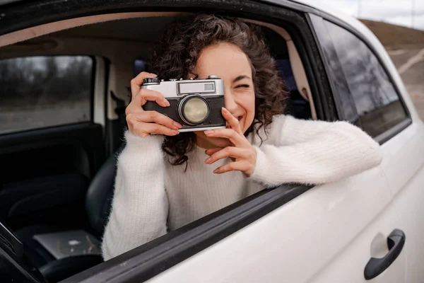 Lány fotózni a régi fényképezőgép az autó — Stock Fotó