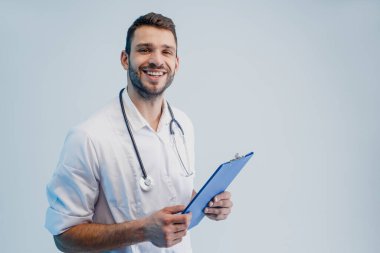 Stetoskop ve not panosuyla gülümseyen erkek doktor