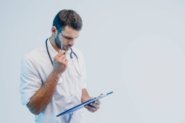 Düşünceli erkek doktor panoda bir şey okudu.