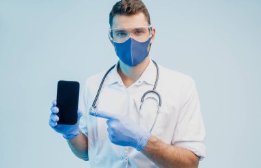 Avrupalı erkek doktor elinde cep telefonu gösteriyor