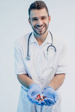 Gülümseyen Avrupalı erkek doktor ilaç gösteriyor