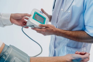 Doktor, tonometresi olan hastanın nabzını kontrol et.