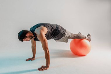 Sporcu fitness topuyla şınav çeker.