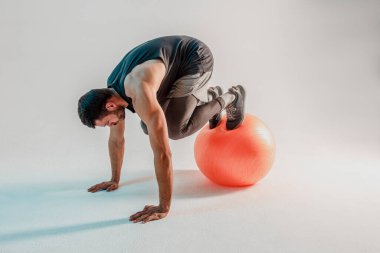 Sporcu fitness topuyla şınav çeker.