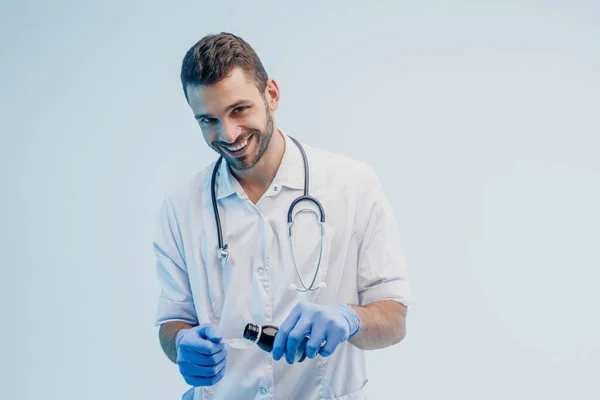 Médico masculino despejando xarope de frasco para colher — Fotografia de Stock