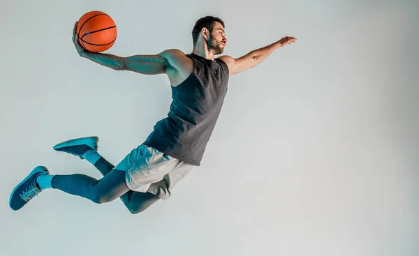 Sporcu zıplayıp basketbol topu atmak istiyor.