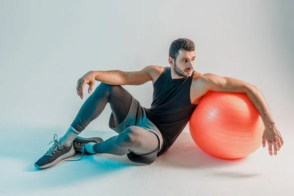 フィットネスボール付きの床に座っているスポーツマン — ストック写真