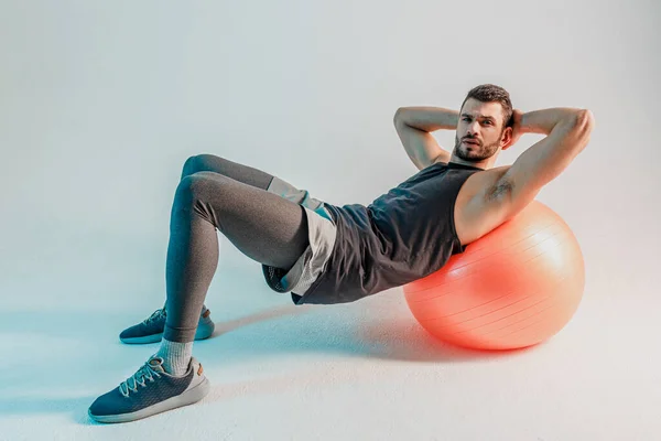 Sportsman do push ups on fitness ball