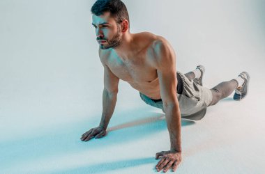 Genç sporcu stüdyoda antrenmandan önce esneme hareketleri yapıyor.