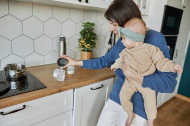 Anne süt hazırlamak için şişeye su dolduruyor.