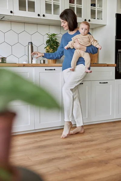 Anne süt hazırlamak için şişeye su dolduruyor.