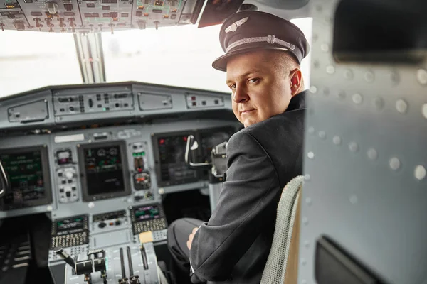 Male pilot in cockpit of passenger airplane jet