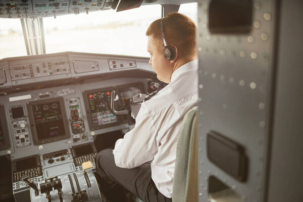 Летчик-мужчина в кабине пассажирского самолета