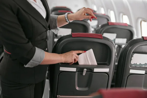 Letuška strčit ubrousek v sedadle letadla jet — Stock fotografie