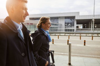 Uçak ekibi havaalanının yanındaki kaldırımda yürüyor.