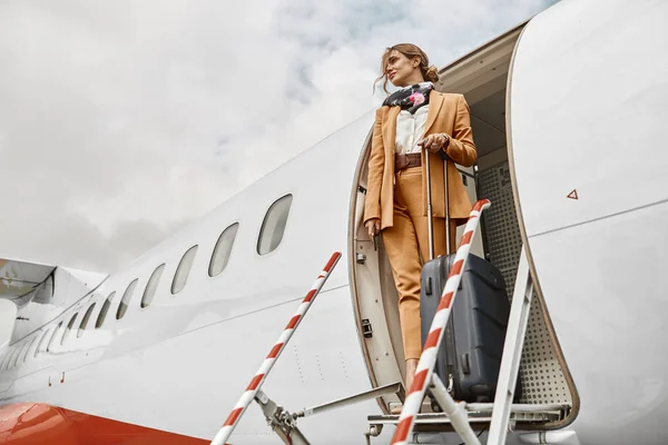 Empresária com bagagem em escada de avião — Fotografia de Stock