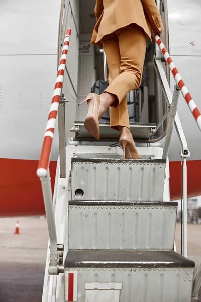 İş kadını bavullarını merdivenden uçağa taşır. — Stok fotoğraf