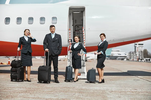 Letecký tým stojí na přistávací dráze poblíž letadla — Stock fotografie