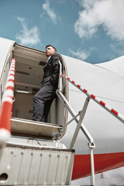 Бортпроводник, стоящий на частном самолете — стоковое фото