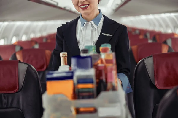 Aeromoça com carrinho de comida na cabine do avião — Fotografia de Stock