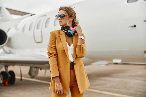 Uçak jetinin arka planında kendine güvenen bir iş kadını. — Stok fotoğraf