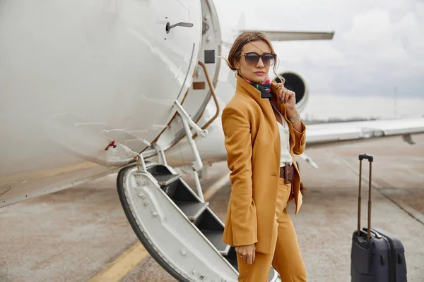 Mujer de negocios de pie cerca de avión privado jet — Foto de Stock
