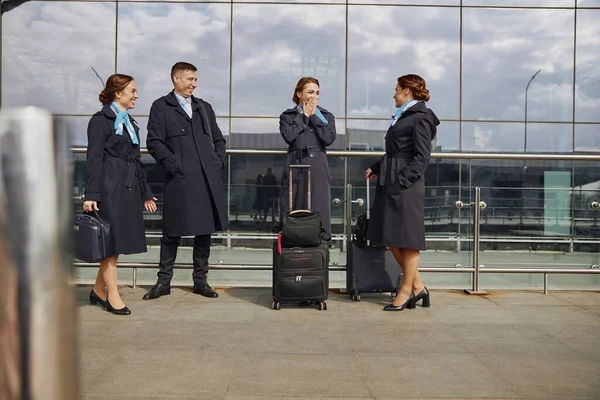 Letecký tým stojí a mluvit v blízkosti moderního letiště — Stock fotografie