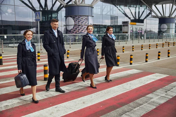 Letecký tým pěšky po silničním přechodu v blízkosti letiště — Stock fotografie