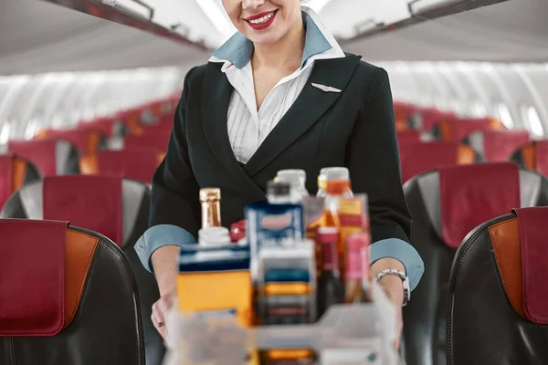 Azafata con carro de comida en cabina de avión Imágenes De Stock Sin Royalties Gratis