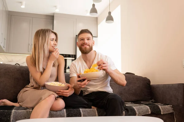 夫婦はソファに座ってテレビや映画を見て — ストック写真