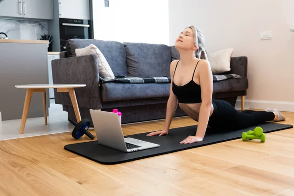 Chica practicando yoga en la colchoneta de fitness en casa — Foto de Stock