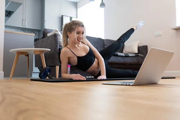 Mujer ver algo en el ordenador portátil y hacer ejercicio — Foto de Stock