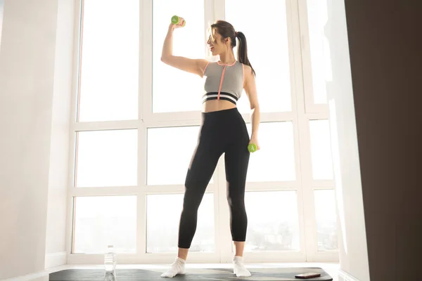 Mujer hacer ejercicio con la mancuerna en la alfombra de fitness — Foto de Stock