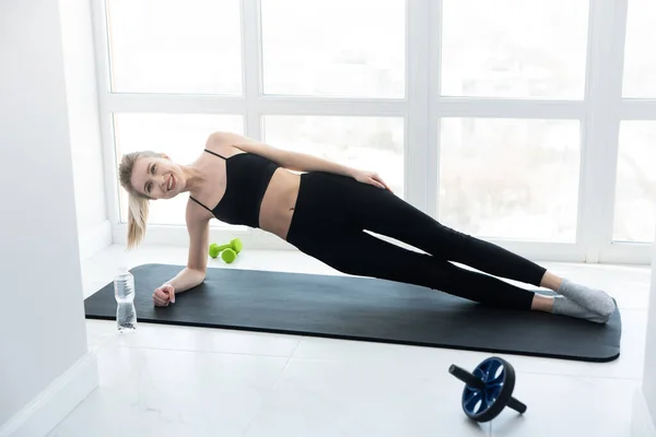 Deportista europea haciendo ejercicio en la alfombra de fitness — Foto de Stock