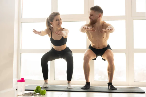 Deportista y deportista se sienta en la alfombra de fitness — Foto de Stock