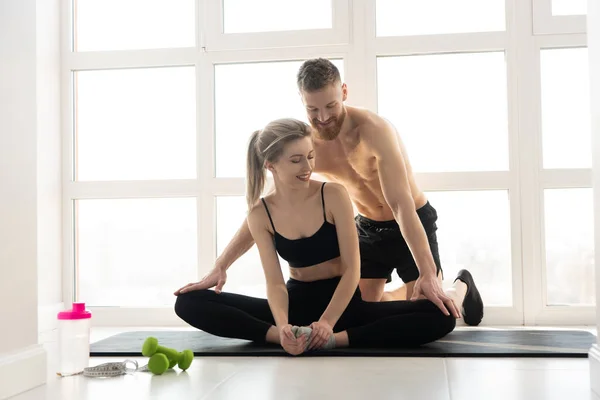 Entrenador de fitness mostrando estiramiento a mujer deportiva — Foto de Stock