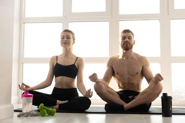 Pareja deportiva practicando yoga en colchoneta de fitness. — Foto de Stock